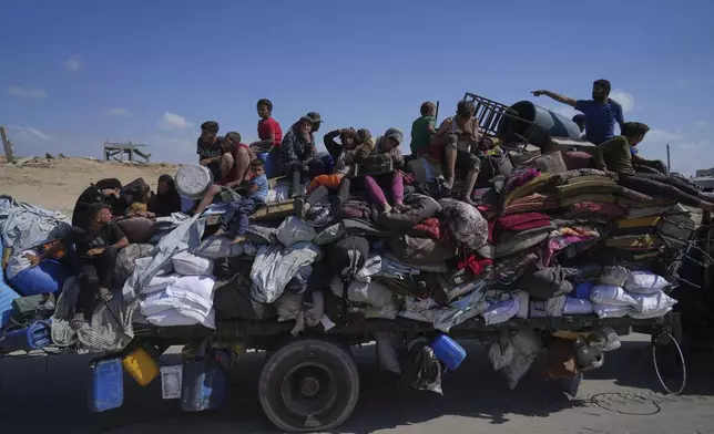Displaced Palestinians fleeing northern Gaza carry their belongings along the coastal road toward southern Gaza, Tuesday, Sept. 9, 2025, after the Israeli army issued evacuation orders from Gaza City. (AP Photo/Jehad Alshrafi)