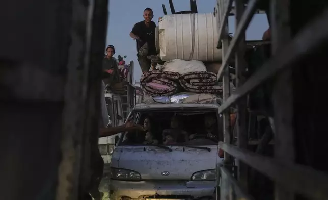 Displaced Palestinians flee Gaza City, carrying their belongings along the coastal road in Nuseirat toward the southern Gaza Strip, Friday, Sept. 19, 2025. (AP Photo/Abdel Kareem Hana)