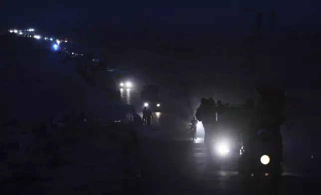 Displaced Palestinians fleeing northern Gaza carry their belongings along the coastal road toward southern Gaza, Saturday, Sept. 6, 2025. (AP Photo/Jehad Alshrafi)