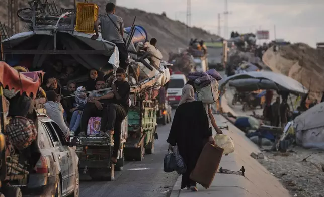 Displaced Palestinians fleeing northern Gaza carry their belongings along the coastal road toward southern Gaza, Thursday, Sept. 11, 2025, after the Israeli army issued evacuation orders from Gaza City. (AP Photo/Jehad Alshrafi)
