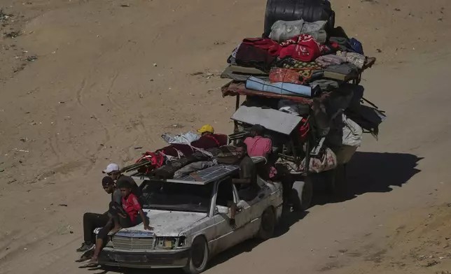 Displaced Palestinians fleeing northern Gaza carry their belongings along the coastal road toward southern Gaza, Wednesday, Sept. 10, 2025, after the Israeli army issued evacuation orders from Gaza City. (AP Photo/Abdel Kareem Hana)