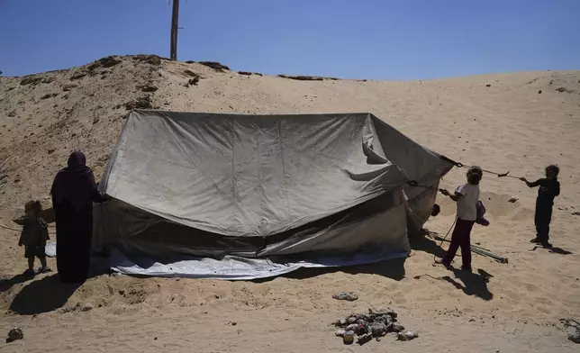 Members of the Abdullah family who were evacuated from Gaza City set up their tent in a camp for displaced Palestinians in Muwasi, an area that Israel has designated as a safe zone, in Khan Younis southern Gaza Strip, Wednesday, Sept. 10, 2025. (AP Photo/Jehad Alshrafi)