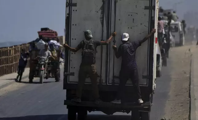 Displaced Palestinians fleeing northern Gaza carry their belongings along the coastal road toward southern Gaza, Tuesday, Sept. 9, 2025, after the Israeli army issued evacuation orders from Gaza City. (AP Photo/Jehad Alshrafi)