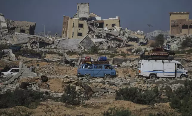 Displaced Palestinians fleeing northern Gaza carry their belongings along the coastal road toward southern Gaza, Wednesday, Sept. 10, 2025, after the Israeli army issued evacuation orders from Gaza City. (AP Photo/Abdel Kareem Hana)
