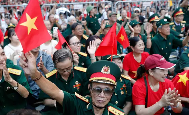 People wait to watch a parade marking Vietnam's 80th National Day anniversary, at a street in Hanoi, Vietnam Tuesday, Sept. 2, 2025. (Luong Thai Linh/Pool Photo via AP)
