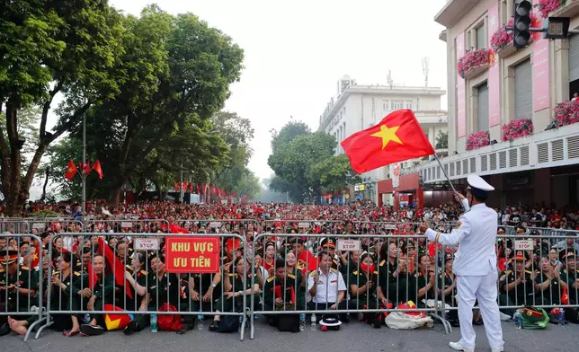 People wait to watch a parade marking Vietnam's 80th National Day anniversary, at a street in Hanoi, Vietnam Tuesday, Sept. 2, 2025. (Luong Thai Linh/Pool Photo via AP)