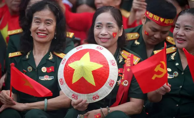 People wait to watch a parade marking Vietnam's 80th National Day anniversary, at a street in Hanoi, Vietnam Tuesday, Sept. 2, 2025. (Luong Thai Linh/Pool Photo via AP)
