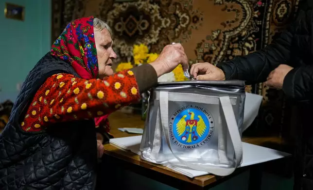 FILE - A woman casts her vote in a mobile ballot box during a presidential election runoff, in the village of Ciopleni, Moldova, Sunday, Nov. 3, 2024. (AP Photo/Vadim Ghirda, File)