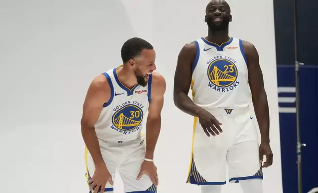 Golden State Warriors guard Stephen Curry, left, laughs with forward Draymond Green while posing for photos during the NBA basketball team's media day in San Francisco, Monday, Sept. 29, 2025. (AP Photo/Jeff Chiu)