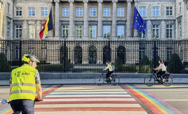 People cycle past the Belgian Parliament in Brussels, Belgium, Tuesday, Sept. 2, 2025. (AP Photo/Sylvain Plazy)