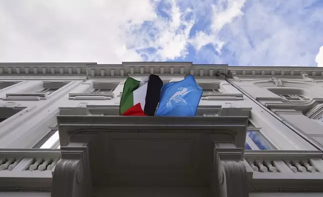A Palestinian and World Peace flag flap in the wind as they are displayed from a balcony of a house in Antwerp, Belgium, Tuesday, Sept. 2, 2025. (AP Photo/Virginia Mayo)