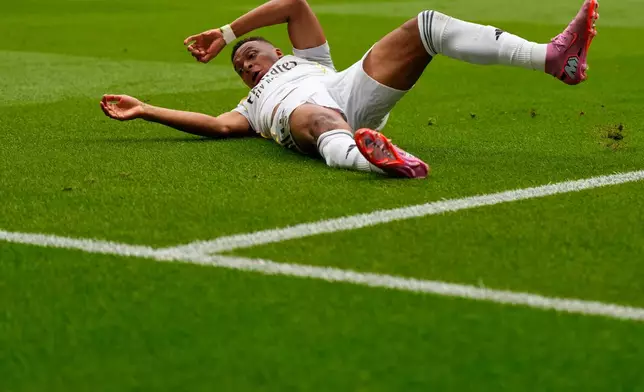 Real Madrid's Kylian Mbappe falls as he battles for the ball during the Spanish La Liga soccer match between Atletico Madrid and Real Madrid at Metropolitano stadium, in Madrid, Spain, Saturday, Sept. 27, 2025. (AP Photo/Manu Fernandez)