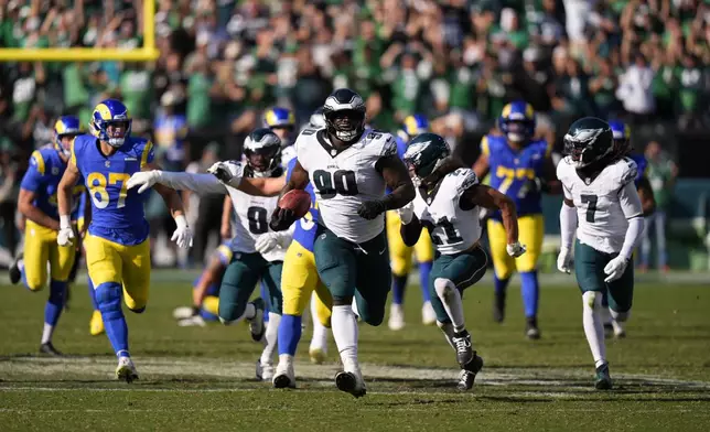Philadelphia Eagles defensive tackle Jordan Davis (90) runs the ball back for a touchdown after blocking a field goal attempt as time expires during the second half of an NFL football game against the Los Angeles Rams Sunday, Sept. 21, 2025, in Philadelphia. (AP Photo/Chris Szagola)