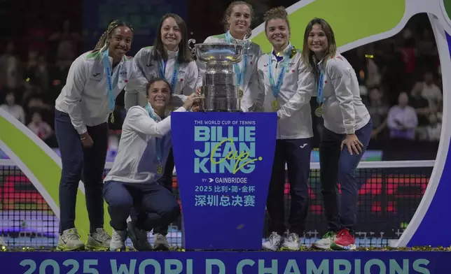Italy's tennis team pose with the trophy on podium after winning the Billie Jean King Cup final against the United States, at the Shenzhen Bay Sports Center Arena, in Shenzhen, China's Guangdong province, Sunday, Sept. 21, 2025. (AP Photo/Andy Wong)