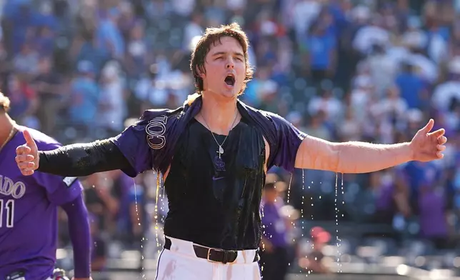 Colorado Rockies' Mickey Moniak yells after being doused by Orlando Arcia after hitting a walkoff RBI single off Chicago Cubs relief pitcher Daniel Palencia in the ninth inning of a baseball game Sunday, Aug. 31, 2025, in Denver. (AP Photo/David Zalubowski)