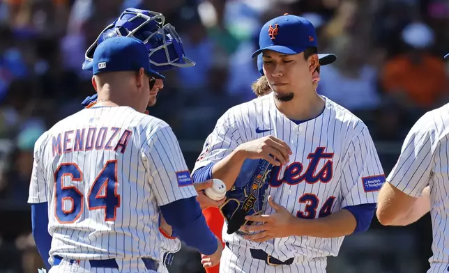 New York Mets manager Carlos Mendoza (64) takes the ball from pitcher Kodai Senga (34) during the fifth inning of a baseball game against the Miami Marlins, Sunday, Aug. 31, 2025, in New York. (AP Photo/Noah K. Murray)