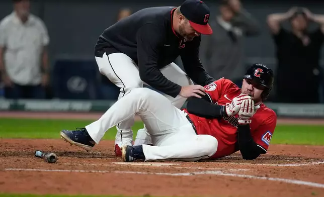 CORRECTION CORRECTS HITTING ON THE FACE BY PITCH - Cleveland Guardians manager Stephen Vogt, left, attends to David Fry after Fry was hit in the face by a pitch in the sixth inning of a baseball game against the Detroit Tigers in Cleveland, Tuesday, Sept. 23, 2025. (AP Photo/Sue Ogrocki)