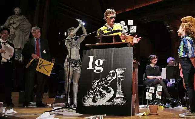 FILE - Michael Smith, a Cornell University graduate student who allowed himself to be stung about 200 times by bees to determine where you feel the most pain on the body from a sting, makes an acceptance speech while being honored during a performance at the Ig Nobel Prize ceremony in Cambridge, Mass., Thursday, Sept. 17, 2015. The Ig Nobel prize is an award handed out by the Annals of Improbable Research magazine for silly sounding scientific discoveries that often have surprisingly practical applications. (AP Photo/Charles Krupa, File)
