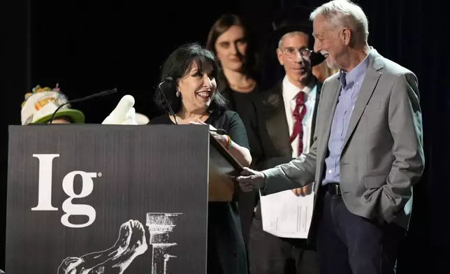 The Ig Nobel Prize for pediatrics is accepted by Julie Mennella and Gary Beauchamp, for studying what a nursing baby experiences when the baby's mother eats garlic, Thursday, Sept. 18, 2025, in Boston. (AP Photo/Robert F. Bukaty)