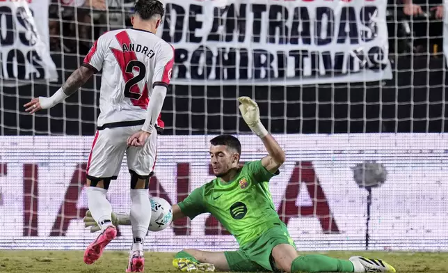 Barcelona's goalkeeper Joan García makes a save from Rayo's Andrei Ratiu during the Spanish La Liga soccer match between Rayo Vallecano and FC Barcelona at the Vallecas stadium in Madrid, Spain, Sunday, Aug. 31, 2025. (AP Photo/Manu Fernandez)