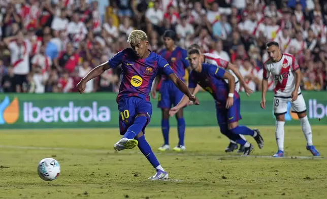Barcelona's Lamine Yamal scores the opening goal from the penalty spot during the Spanish La Liga soccer match between Rayo Vallecano and FC Barcelona at the Vallecas stadium in Madrid, Spain, Sunday, Aug. 31, 2025. (AP Photo/Manu Fernandez)