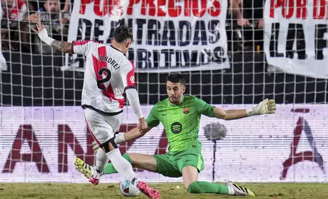 Barcelona's goalkeeper Joan García makes a save from Rayo's Andrei Ratiu during the Spanish La Liga soccer match between Rayo Vallecano and FC Barcelona at the Vallecas stadium in Madrid, Spain, Sunday, Aug. 31, 2025. (AP Photo/Manu Fernandez)