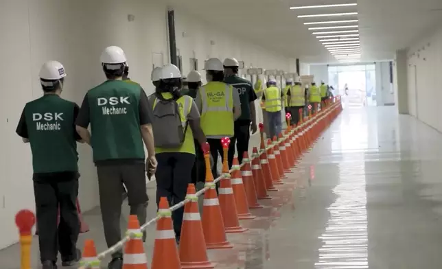 This image from video provided by U.S. Immigration and Customs Enforcement via DVIDS shows manufacturing plant employees being escorted outside the Hyundai Motor Group’s electric vehicle plant, Thursday, Sept. 4, 2025, in Ellabell, Ga. (Corey Bullard/U.S. Immigration and Customs Enforcement via AP)