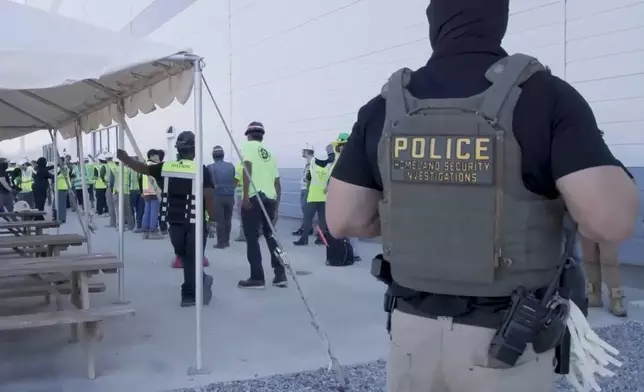 This image from video provided by U.S. Immigration and Customs Enforcement via DVIDS shows manufacturing plant employees being escorted outside the Hyundai Motor Group’s electric vehicle plant, Thursday, Sept. 4, 2025, in Ellabell, Ga. (Corey Bullard/U.S. Immigration and Customs Enforcement via AP)