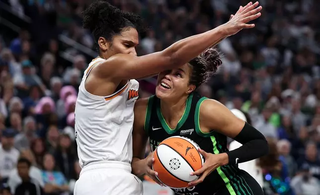 Minnesota Lynx forward Napheesa Collier, right, drives toward the basket as Phoenix Mercury forward Alyssa Thomas defends during the second half of Game 2 of a WNBA basketball playoff semifinals series Tuesday, Sept. 23, 2025, in Minneapolis. (AP Photo/Matt Krohn)