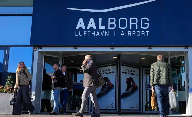 People walk outside Aalborg Airport in Denmark, Thursday, Sept. 25, 2025, after drones were observed on the airport on Wednesday evening and the night to Thursday, and the airspace over the airport was closed. (Bo Amstrup/Ritzau Scanpix via AP)