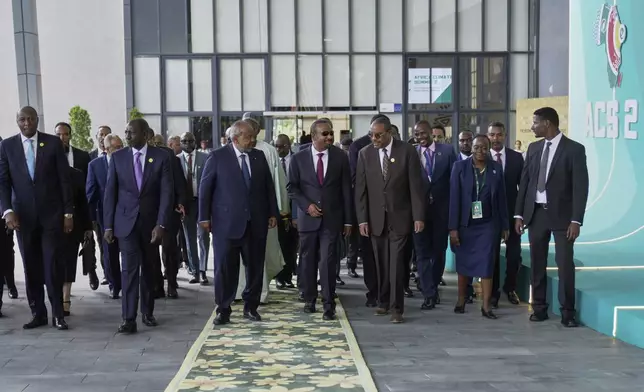 African heads of state and government representatives walk into the plenary hall for the opening of the Second Africa Climate Summit (ACS2) in Addis Ababa, Ethiopia, Monday, Sept. 8, 2025. (AP Photo/Brian Inganga)