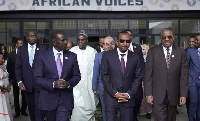 Ethiopian Prime Minister Abiy Ahmed, center, and Kenyan President William Ruto, left, walk with other African heads of state and government representatives ahead of the Second Africa Climate Summit (ACS2) in Addis Ababa, Ethiopia, Monday, Sept. 8, 2025. (AP Photo/Brian Inganga)