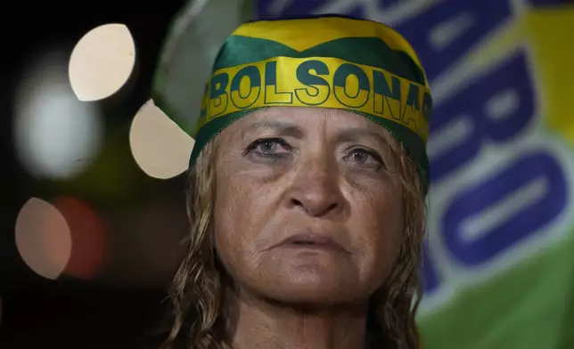 A supporter of former President Jair Bolsonaro prays during a vigil in his support near his home where he is under house arrest, in Brasília, Brazil, Tuesday, Sept. 9, 2025. (AP Photo/Eraldo Peres)