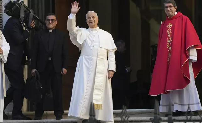 Pope Leo XIV waves flanked by Alejandro Moral Antón, Order of Saint Augustine prior, upon his arrivial at the St. Augustin Basilica in Rome, Monday, Sept. 1, 2025, to address his fellow Augustinians at the start of their global assembly. (AP Photo/Domenico Stinellis)