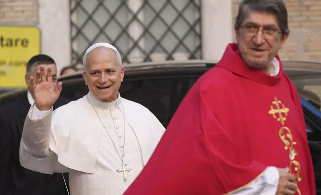 Pope Leo XIV waves flanked by Alejandro Moral Antón, Order of Saint Augustine prior, upon his arrivial at the St. Augustin Basilica in Rome, Monday, Sept. 1, 2025, to address his fellow Augustinians at the start of their global assembly. (AP Photo/Domenico Stinellis)