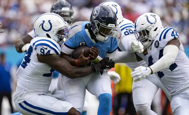Tennessee Titans quarterback Cam Ward (1) is sacked by Indianapolis Colts defensive end Tyquan Lewis (94), defensive tackle Grover Stewart (90) and outside linebacker Zaire Franklin (44) during the first half of an NFL football game Sunday, Sept. 21, 2025, in Nashville, Tenn. (AP Photo/George Walker IV)