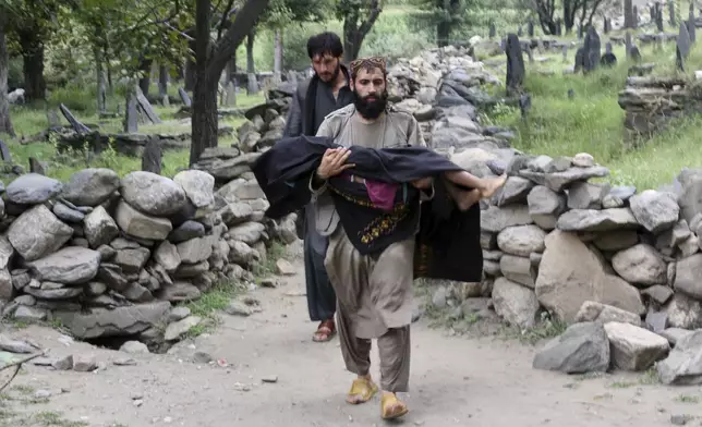 An injured person is carried to a military helicopter that landed to evacuate injured victims of an earthquake that killed many people and destroyed villages in eastern Afghanistan, in Mazar Dara, Kunar province, Monday, Sept. 1, 2025. (AP Photo/Wahidullah Kakar)