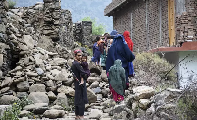 Local residents walk by a house destroyed by an earthquake that killed many people and destroyed villages in eastern Afghanistan, in Mazar Dara, Kunar province, Afghanistan, Monday, Sept. 1, 2025. (AP Photo/Wahidullah Kakar)