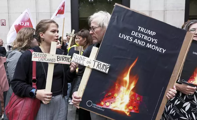 Participants from various women's rights organizations hold signs as they demonstrate regarding the destruction of family planning supplies stockpiled in Belgium, near the U.S. embassy in Brussels, Thursday, Sept. 18, 2025. (AP Photo/Omar Havana)