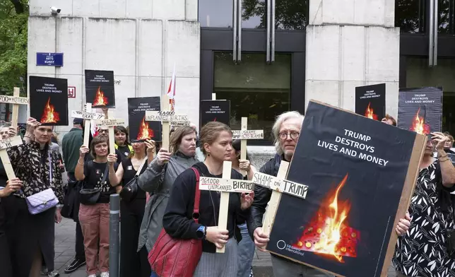 Participants from various women's rights organizations hold signs as they demonstrate regarding the destruction of family planning supplies stockpiled in Belgium, near the U.S. embassy in Brussels, Thursday, Sept. 18, 2025. (AP Photo/Omar Havana)