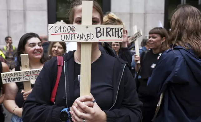 Participants from various women's rights organizations hold signs as they demonstrate regarding the destruction of family planning supplies stockpiled in Belgium, near the U.S. embassy in Brussels, Thursday, Sept. 18, 2025. (AP Photo/Omar Havana)