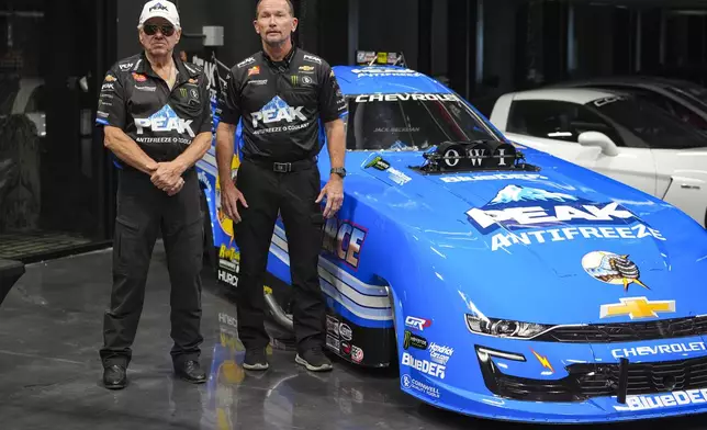 Drag racing car owner John Force, left and funny car driver Jack Beckman pose next to the team's newest car, Thursday, Aug. 28, 2025, in Zionsville, Ind. (AP Photo/Michael Conroy)