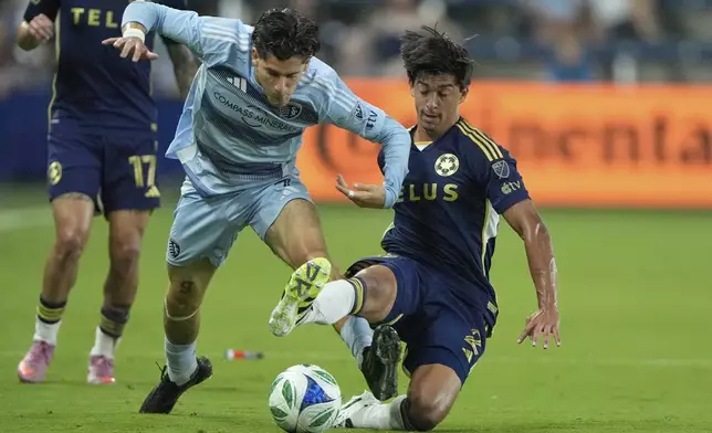 Sporting Kansas City midfielder Santiago Munoz, left, and Vancouver Whitecaps defender Mathias Laborda (2) battle for the ball during the first half of an MLS soccer match Saturday, Sept. 20, 2025, in Kansas City, Kan. (AP Photo/Charlie Riedel)