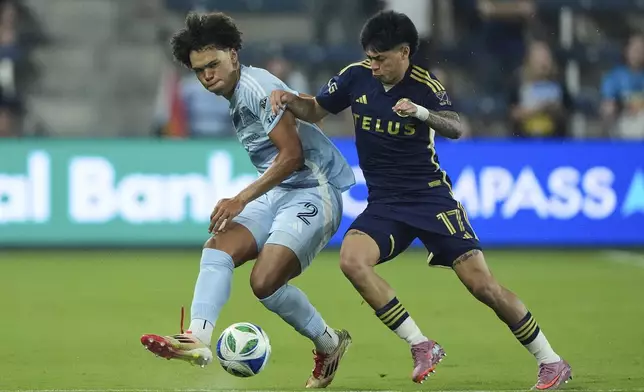 Sporting Kansas City defender Ian James (2) and Vancouver Whitecaps midfielder Kenji Cabrera (17) chase after the ball during the first half of an MLS soccer match Saturday, Sept. 20, 2025, in Kansas City, Kan. (AP Photo/Charlie Riedel)
