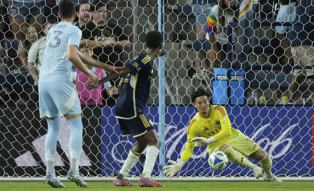 Vancouver Whitecaps goalkeeper Yohei Takaoka (1) blocks a shot during the second half of an MLS soccer match against Sporting Kansas City, Saturday, Sept. 20, 2025, in Kansas City, Kan. (AP Photo/Charlie Riedel)
