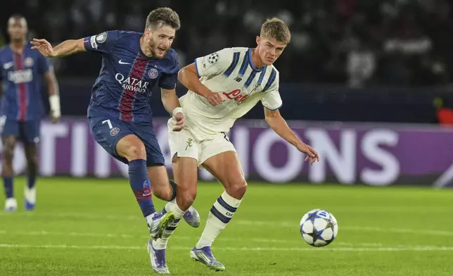 PSG's Khvicha Kvaratskhelia, left, challenges for the ball with Atalanta's Charles De Ketelaere during the Champions League opening phase soccer match between Paris Saint-Germain and Atalanta at the Parc des Princes stadium in Paris, France, Wednesday, Sept. 17, 2025. (AP Photo/Thibault Camus)