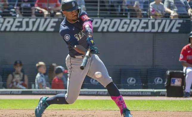 Seattle Mariners' Julio Rodriguez hits an RBI single off Cleveland Guardians relief pitcher Matt Festa during the seventh inning of a baseball game, Sunday, Aug. 31, 2025, in Cleveland. (AP Photo/Phil Long)