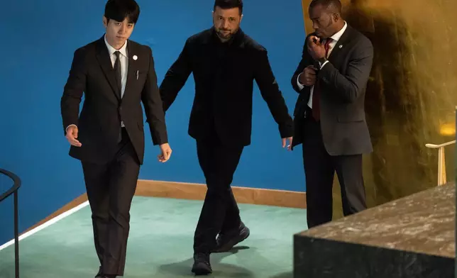 Ukraine President Volodymyr Zelenskyy is escorted to the podium to speak at the 80th session of the United Nations General Assembly, Wednesday, Sept. 24, 2025, at U.N. headquarters. (AP Photo/Yuki Iwamura)