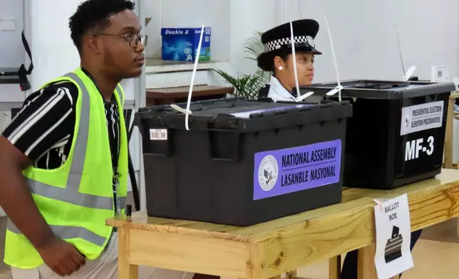 Electoral commission staff monitor voting inside a classroom as people cast their votes at Bel Eau Primary School, Bel Air, Seychelles, on Saturday, Sep. 27, 2025. (AP Photo/Emilie Chetty)