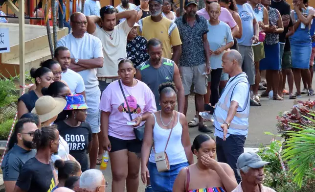 People line up to cast their votes at Beau Vallon Secondary School in Beau Vallon, Seychelles, on Saturday, Sep. 27, 2025. (AP Photo/Emilie Chetty)